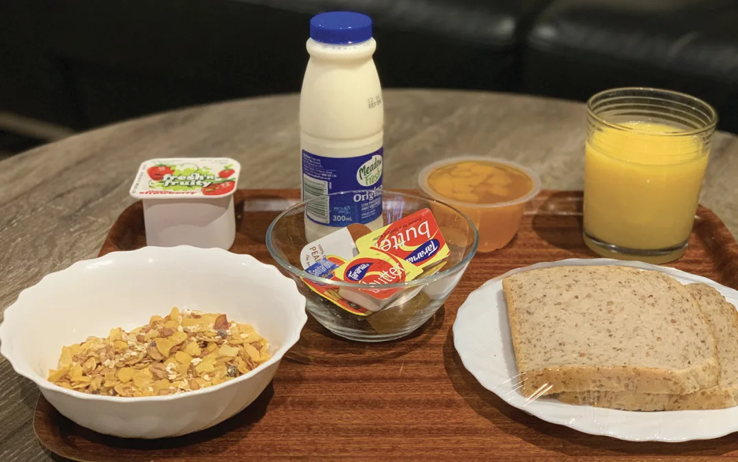Continental breakfast with cereal, milk, yoghurt, fruit, orange juice, bread and spreads